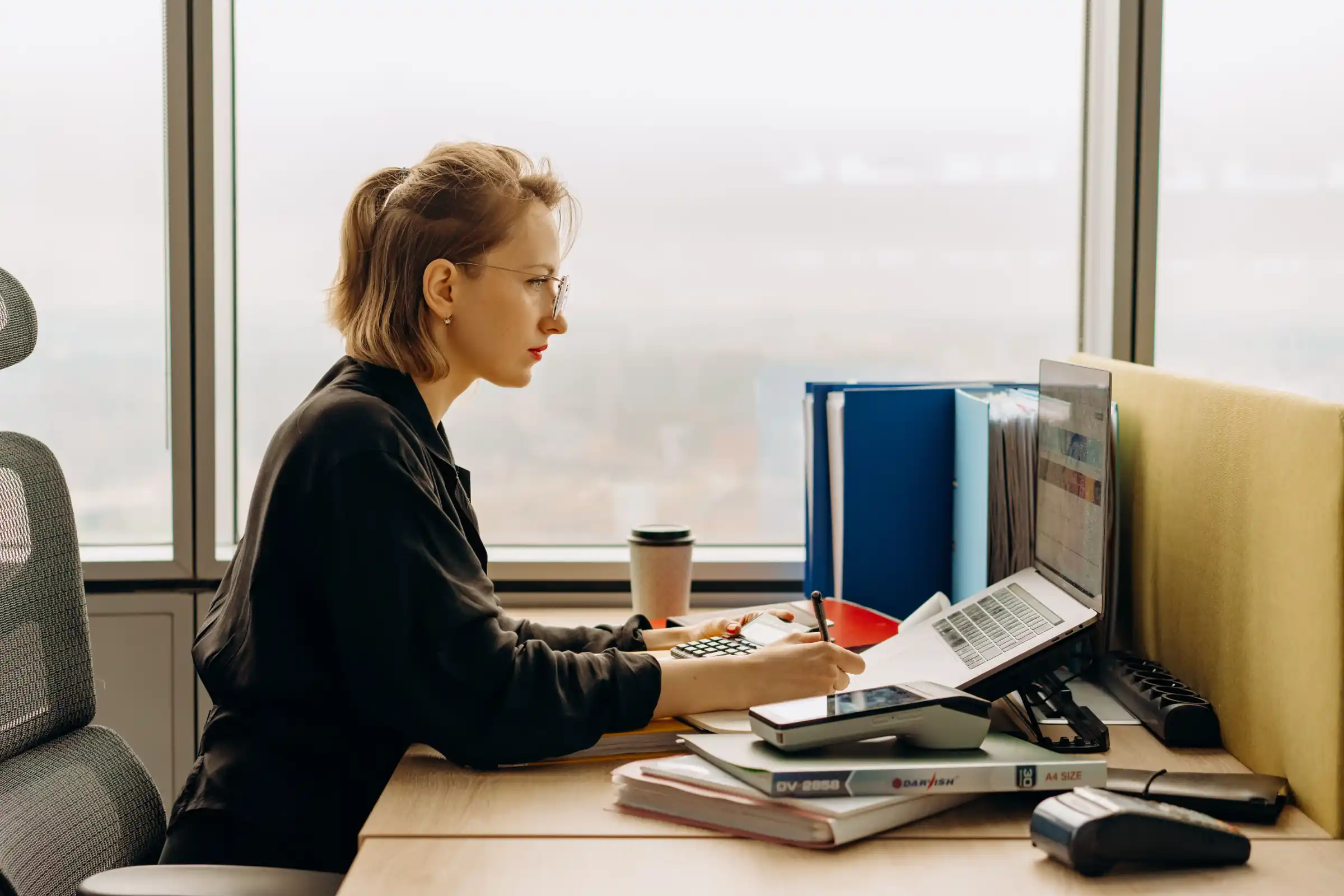 A bookkeeper reconciling business records at a desk
