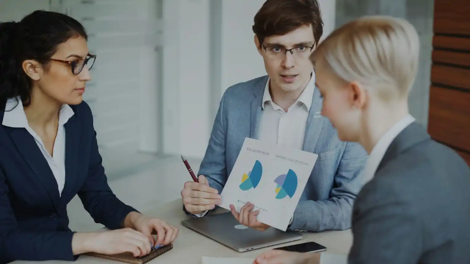A consultant walking a client through findings on a laptop