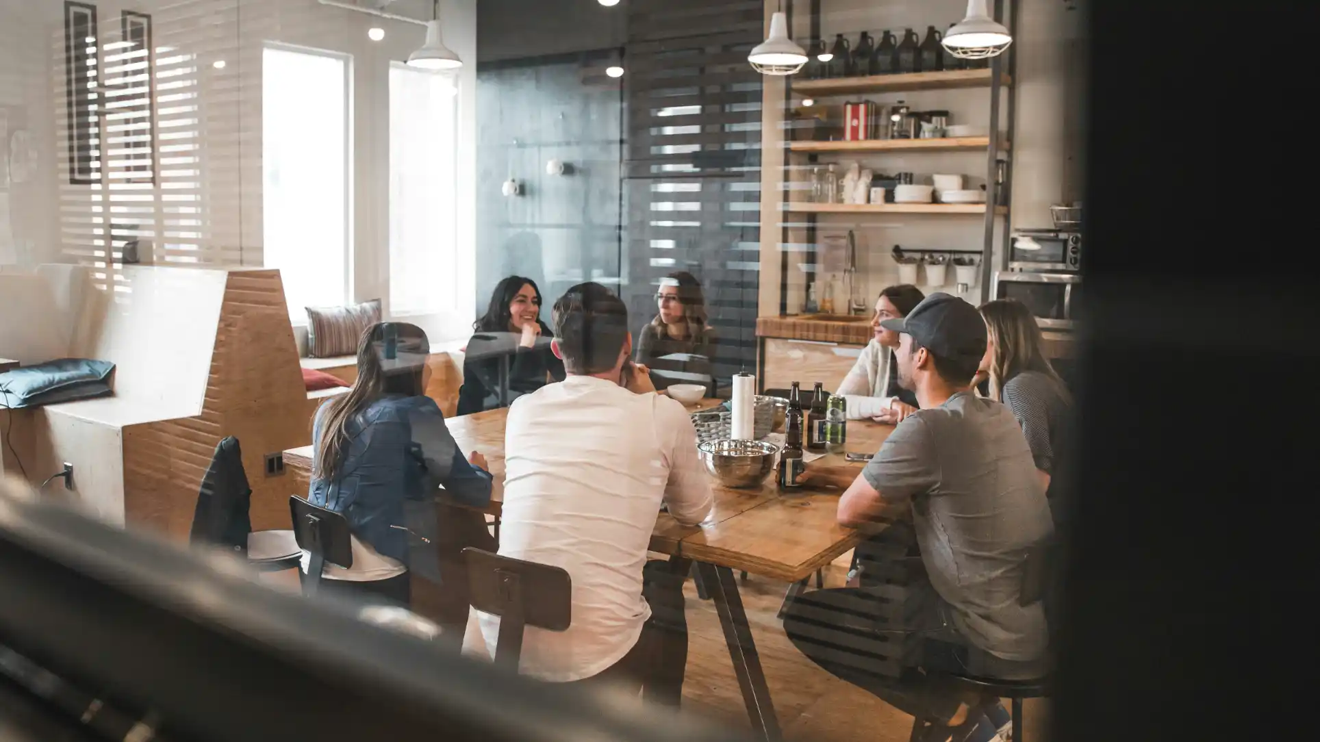 A group of business owners meeting around a long table in a shared office