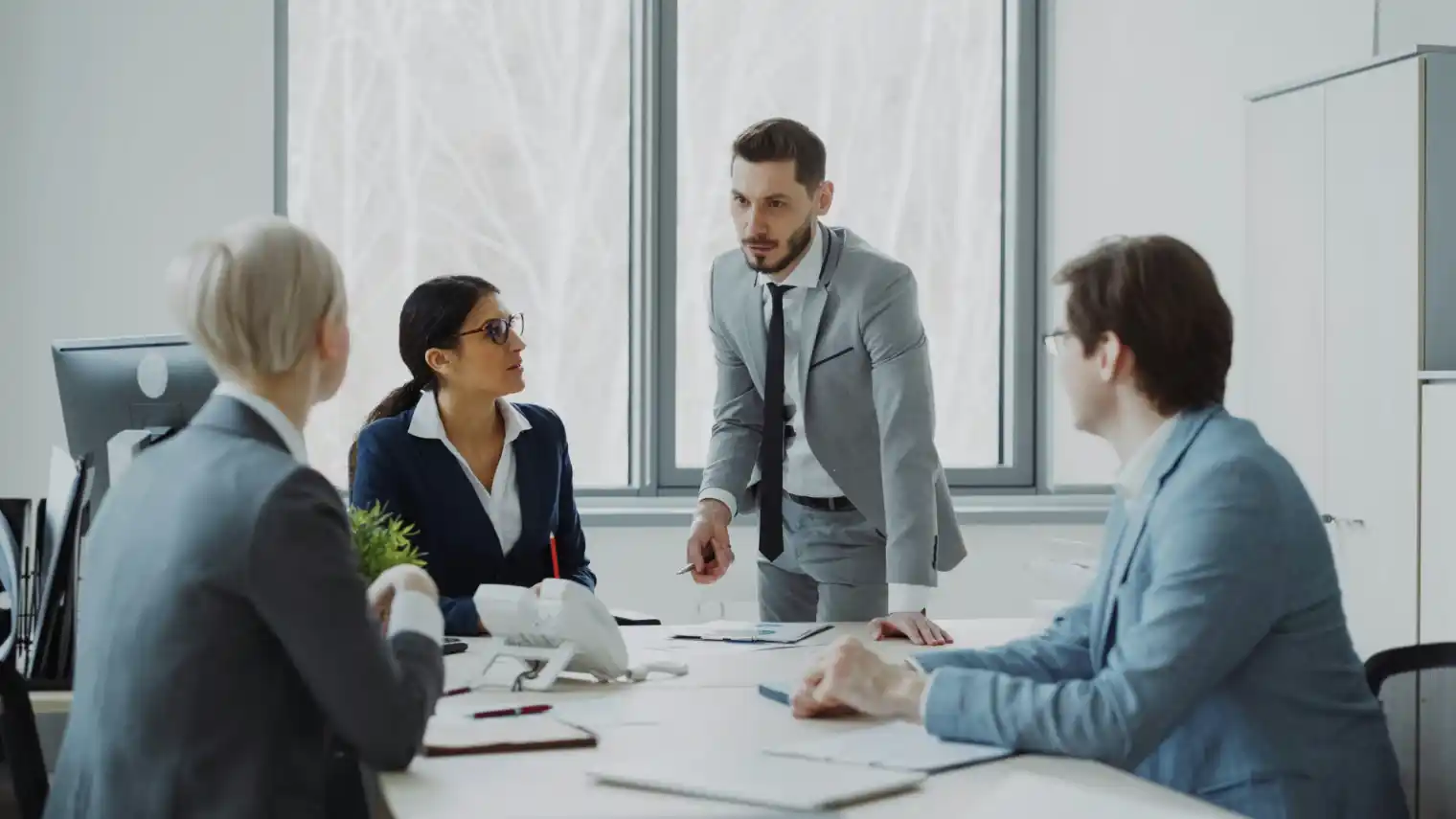 A team of lawyers in a boardroom reviewing a presentation