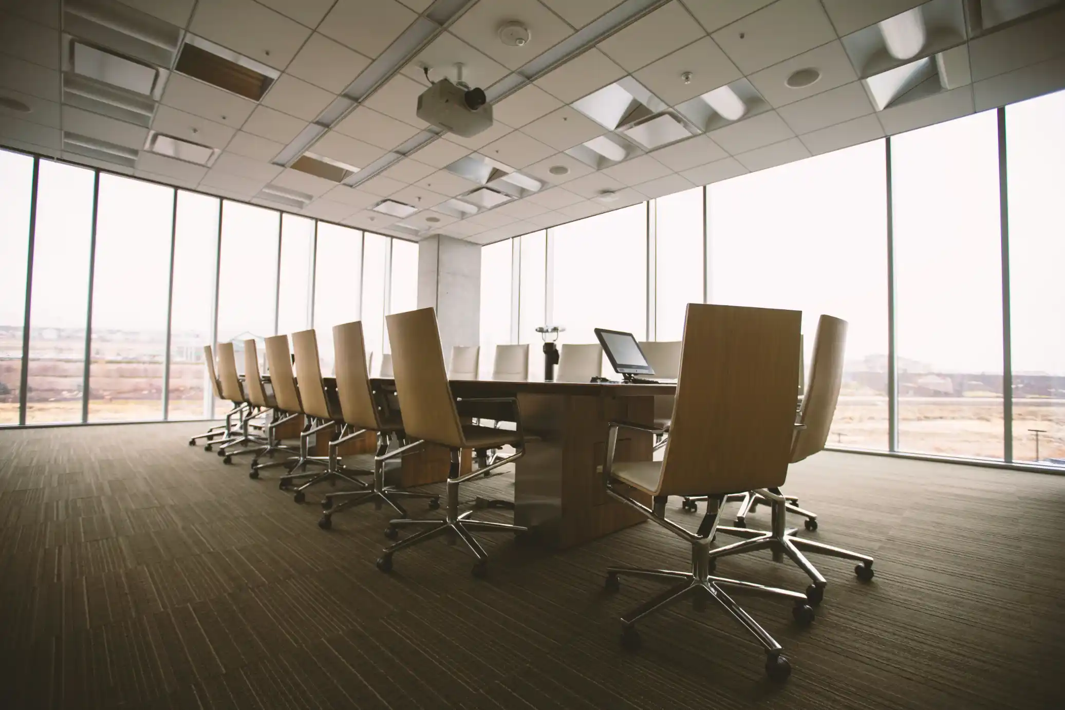 A conference room with a long table and windows overlooking the city