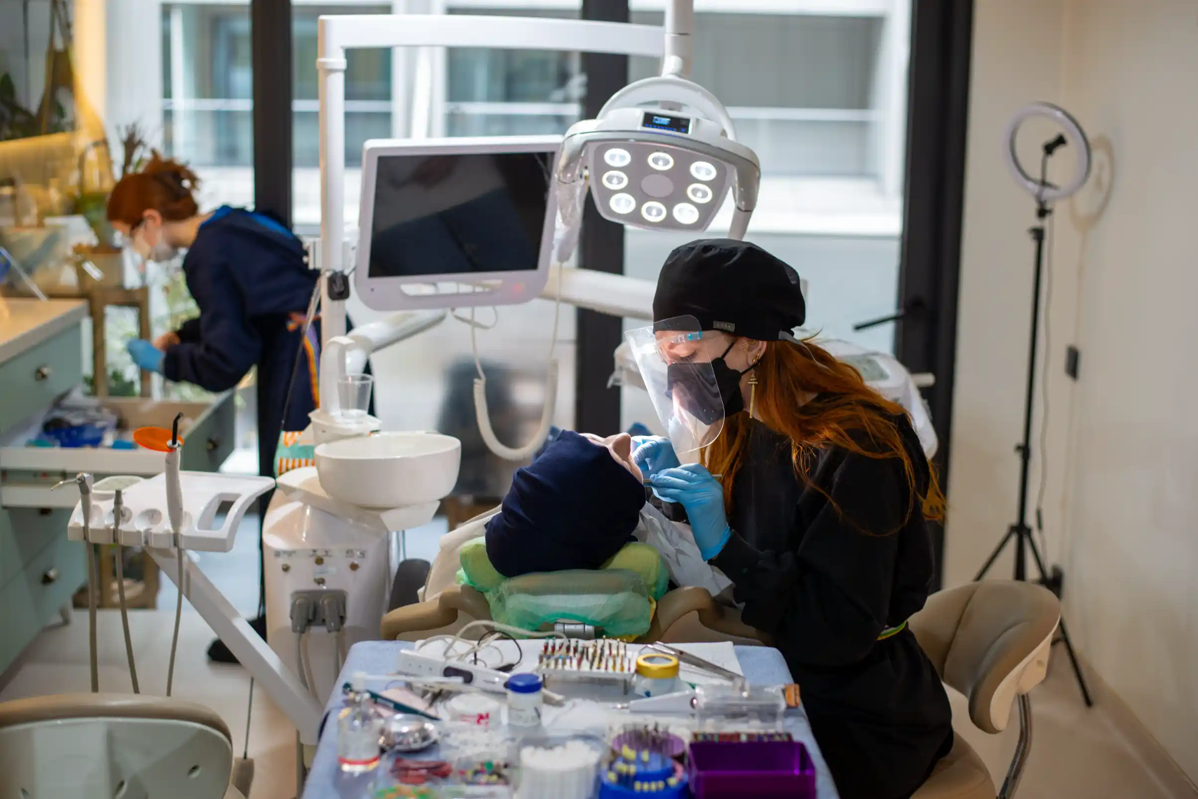 Two dental team members treating a patient in a modern dental operatory