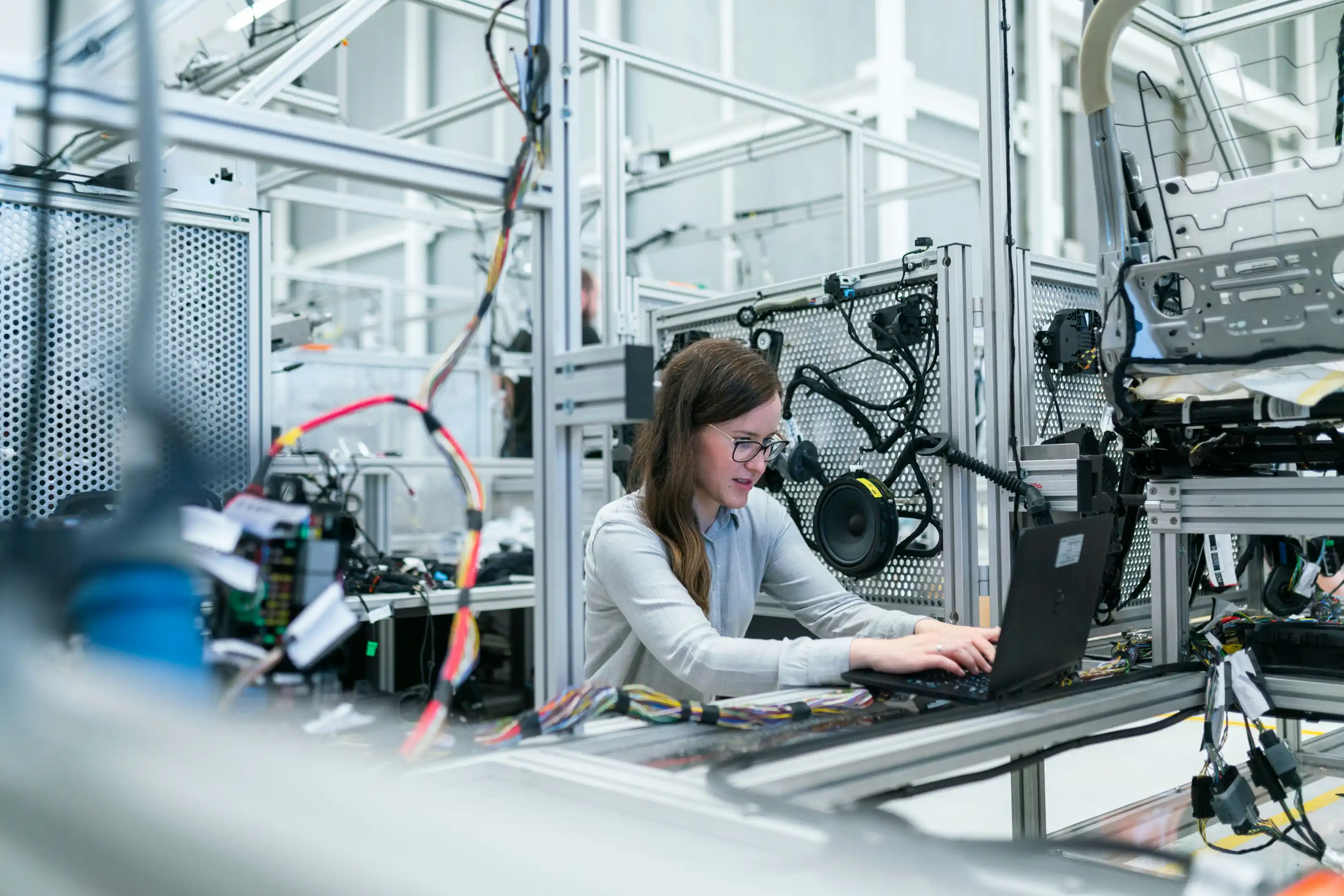 An engineer at a computer workstation on a factory floor