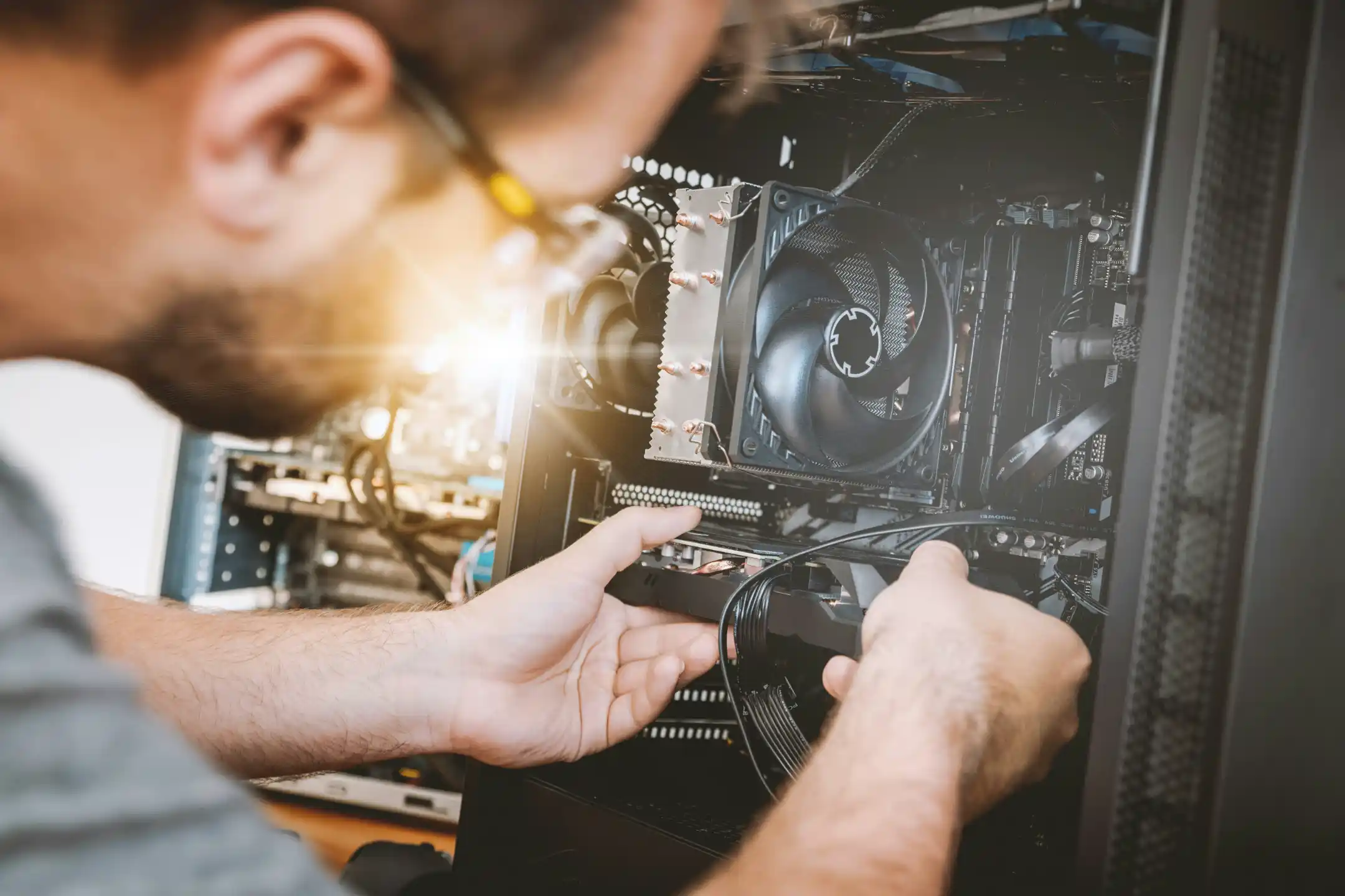 A technician examining computer hardware at a workbench