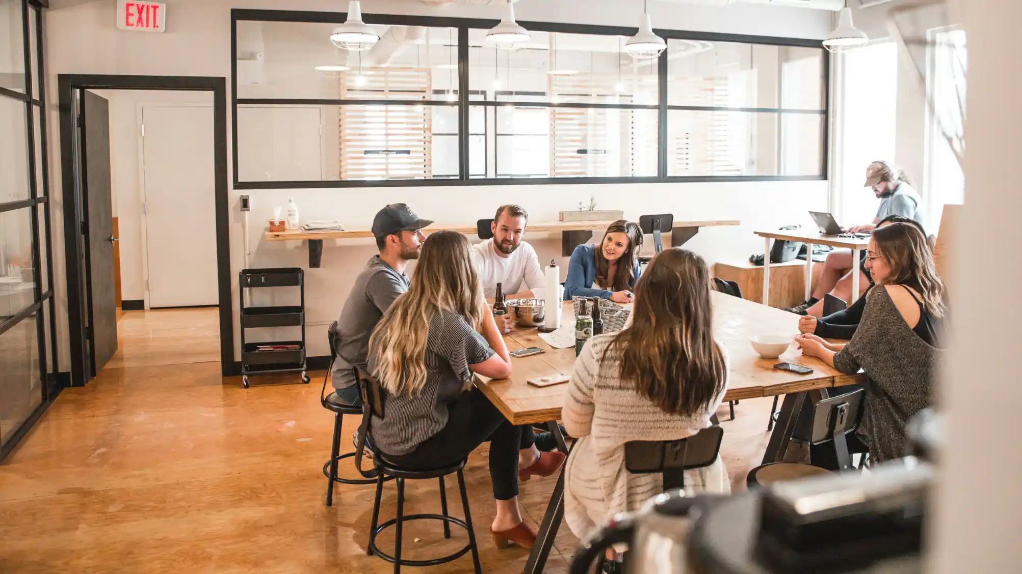 A team meeting around a long table in a glass-walled room