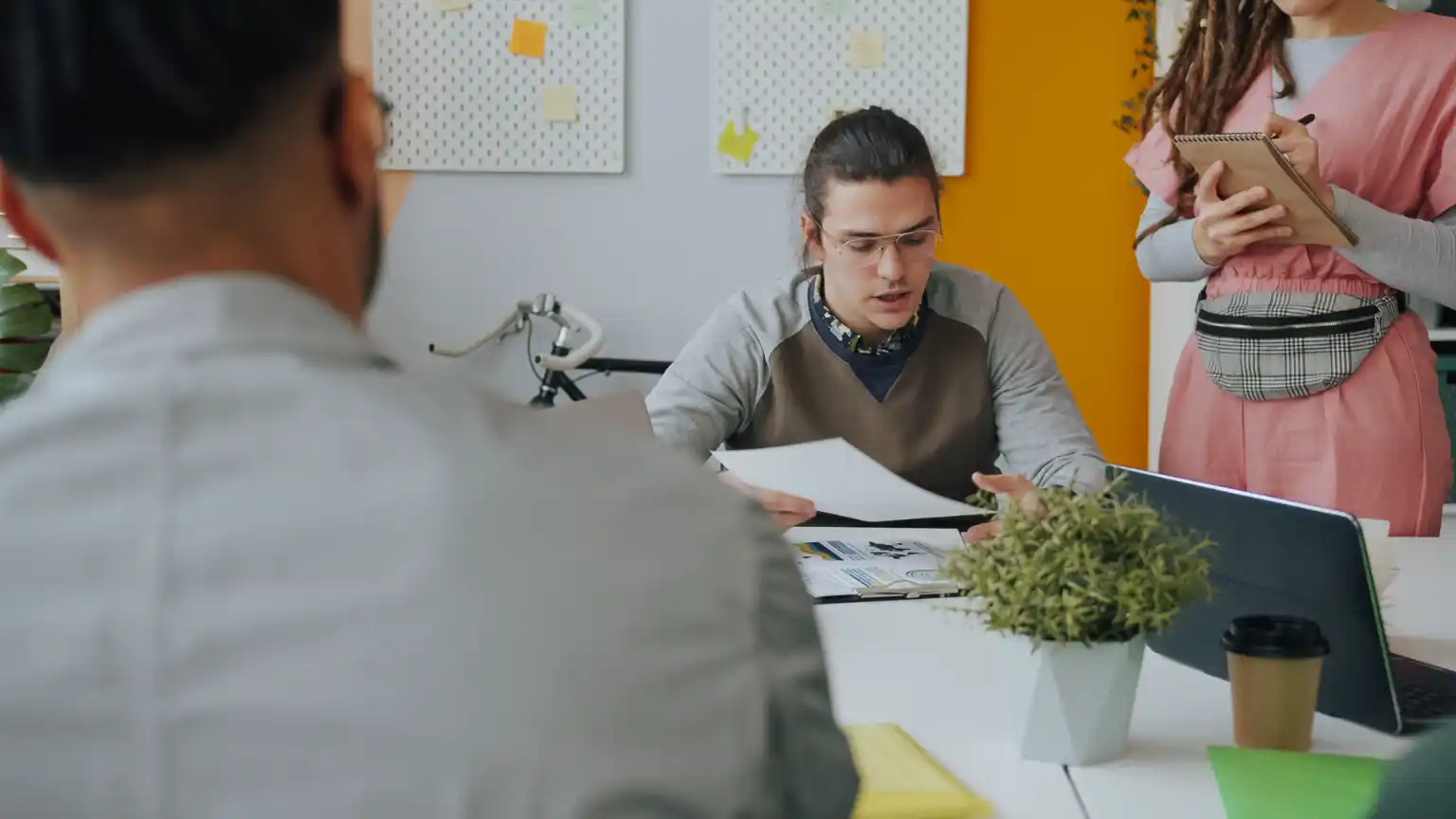 A lawyer meeting business clients across a table with documents